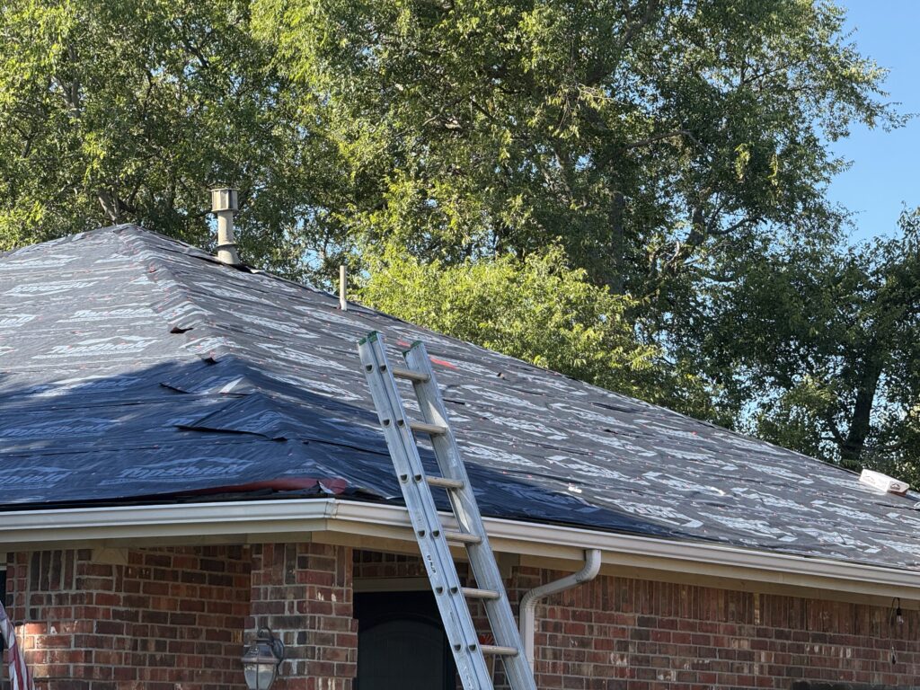 Roof underlayment installed across the slopes and valley of a brick home